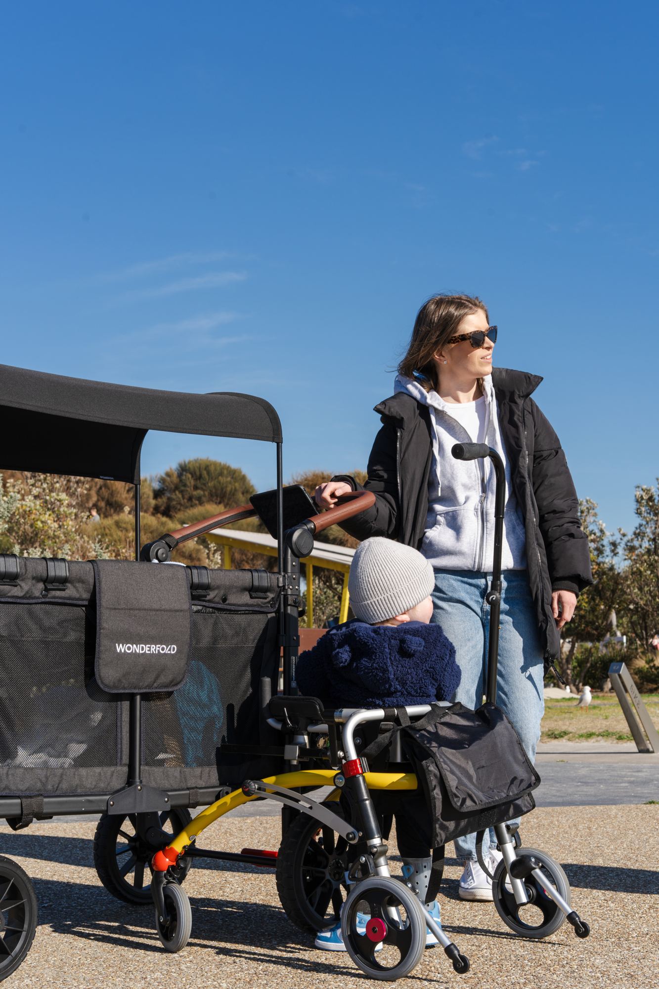 Cody stands with his walker beside his WonderFold as his mum looks on